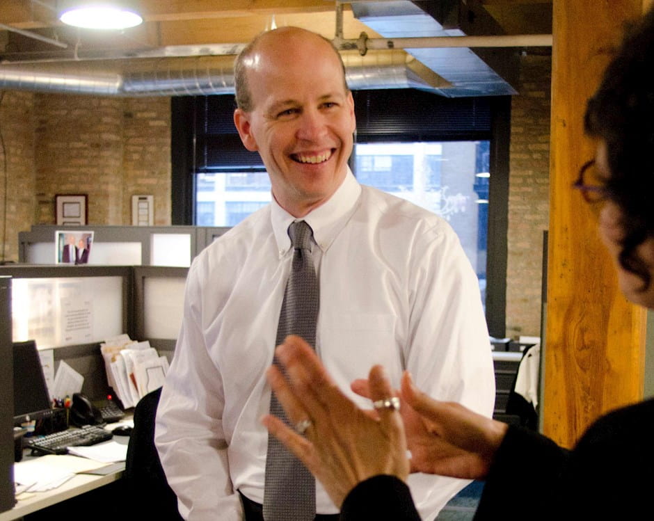 Eric P. Weinheimer smiling in a conversation at the office