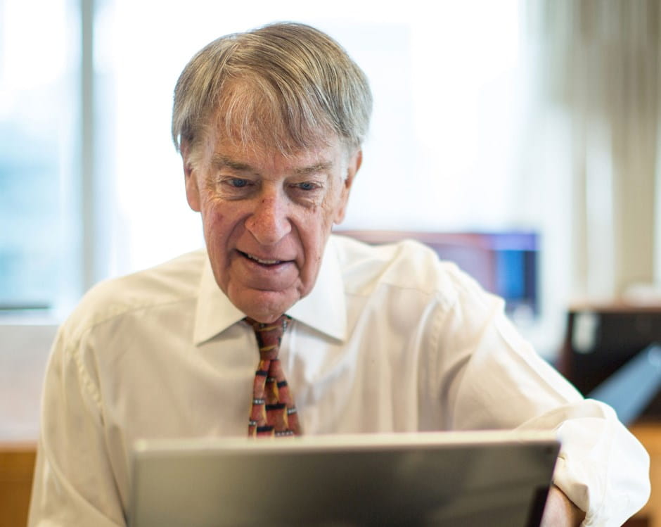 Roger C. Altman working on a laptop
